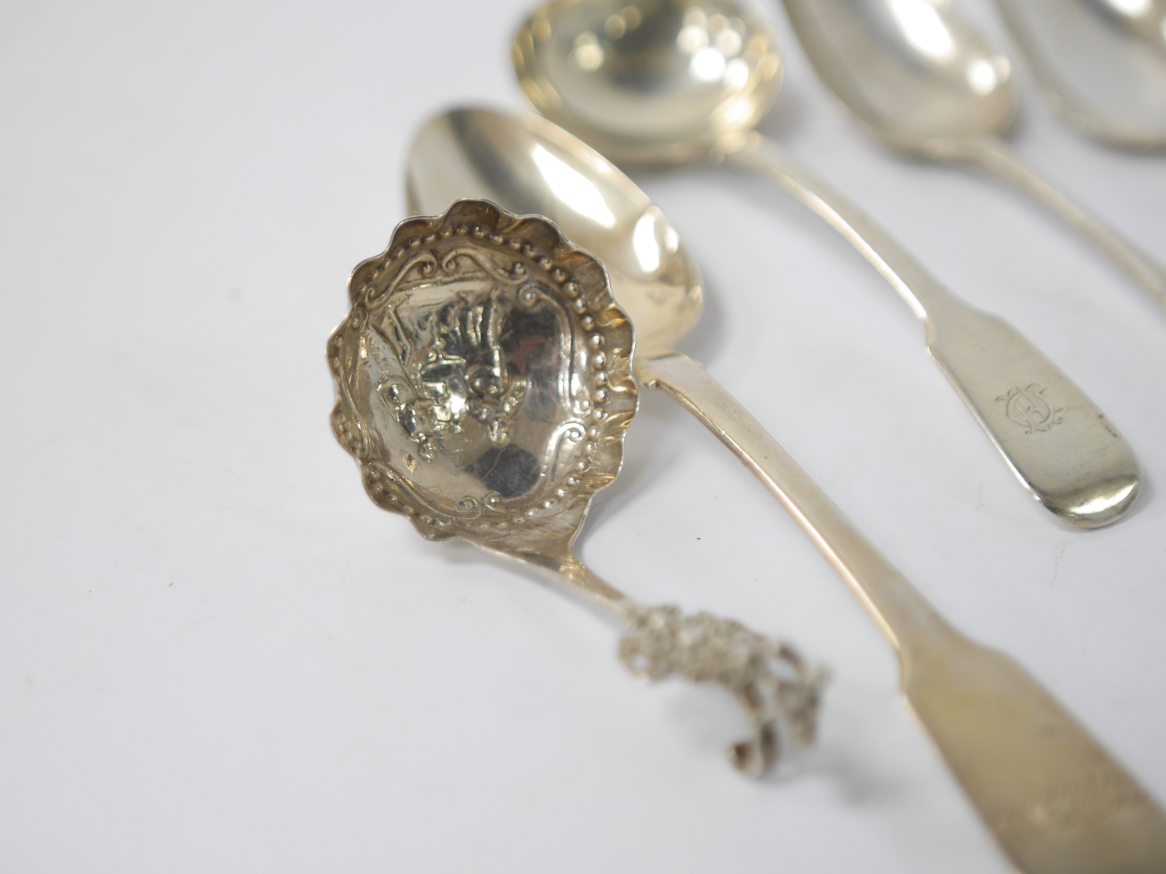 A late 19th century continental silver caddy spoon, with figural terminal, import marks for Sheffield, 1894, together with four assorted 19th century spoons including three table spoons and a sauce ladle, various dates a